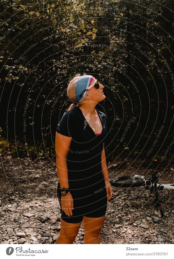 Junger Radfahrer im Wald mtb Fahrradfahren Junge Frau Sportlerin Athlet Mountainbike Pause Natur Landschaft Wärme Sonne Sommer tirkot Radlerhosen Sonnenbrille