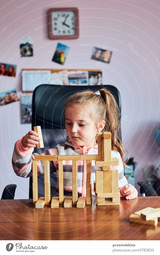 Kleines Mädchen im Vorschulalter spielt mit Holzklötzen Spielzeug, das ein Haus baut Aktivität Klotz Blöcke Baustein bauen Kind Kindheit Konzept Konstruktion