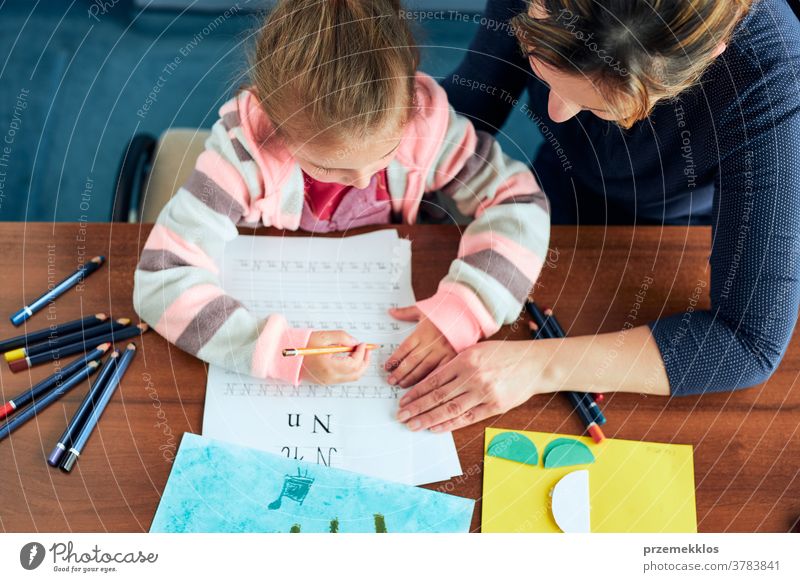 Kleines Mädchen im Vorschulalter, das mit Hilfe seiner Mutter lernt, Briefe zu schreiben Aufmerksamkeit Kaukasier Kind Kindheit niedlich Bildung lehrreich Spaß