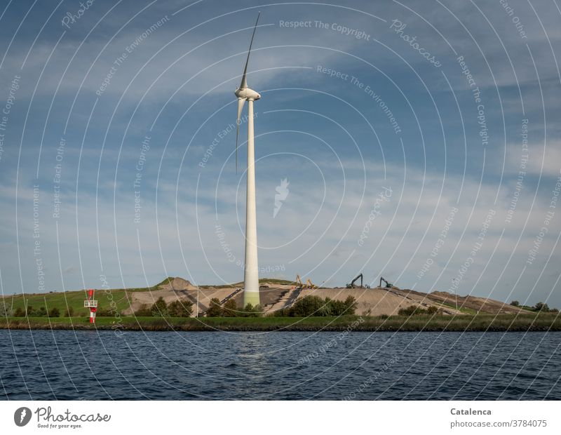 Windrad und Baustelle am Nordseekanal Wolken Himmel Kanal nachhaltig Windkraft erneuerbare Energie Schiffahrt Wasser nass Bagger Baustellenfahrzeug Blau Grün