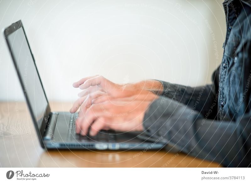 Mann tippt mit schnellen Fingern am Laptop tippen Tastatur beeilung zeitdruck Stress Geschwindigkeit Bewegung Bewegungsunschärfe Business arbeiten Homeoffice