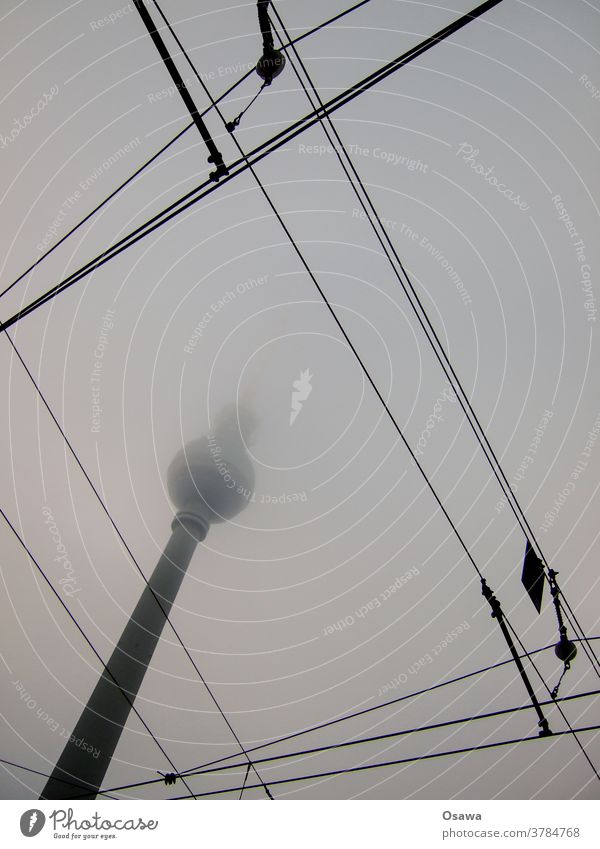 Berliner Fernsehturm im Nebel mit Oberleitungen im Vordergrund Dunst Straßenbahn Grau Wolkenhimmel Bedeckt Alexanderplatz Sehenswürdigkeit Turm Bauwerk