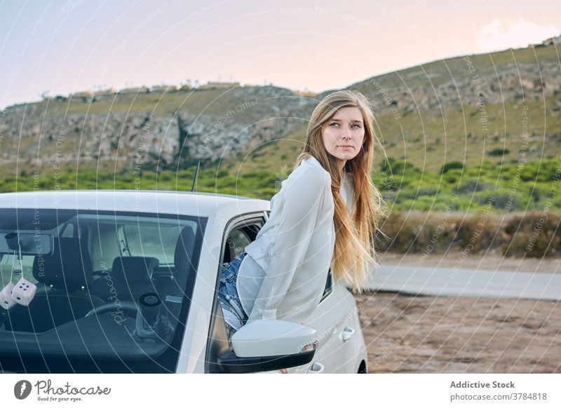 Begeisterte weibliche Reisende aus dem Autofenster PKW Fenster Frau genießen sorgenfrei reisen Reisender Fernweh Automobil Sommer Natur Urlaub Abend ruhen