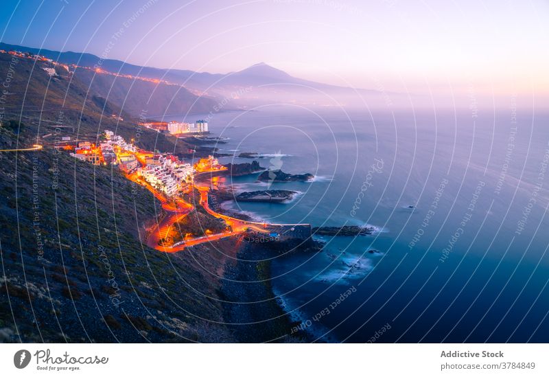 Erstaunliche Kulisse der Küstenstadt bei Sonnenuntergang Stadtbild Straße Verkehr Licht MEER Berge u. Gebirge leuchten Abend Kanarische Inseln Spanien Teneriffa