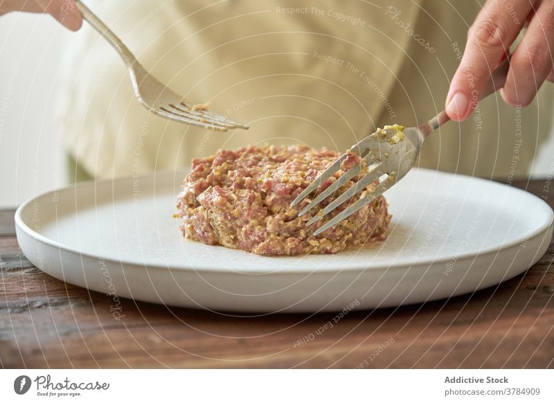 Crop Koch bereitet leckere Steak Tartare im Restaurant roh Rindfleisch Speise Küchenchef Fleisch appetitlich schmackhaft Form verschiedene Reichtum Bestandteil