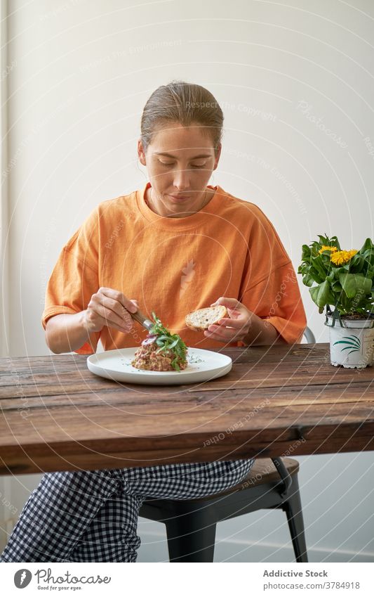 Nachdenkliche Frau mit leckerem Mittagessen zu Hause Steak Tartar heimwärts genießen Speise Freude Sitzen Teller Tisch Glück Feinschmecker Gesundheit Ernährung