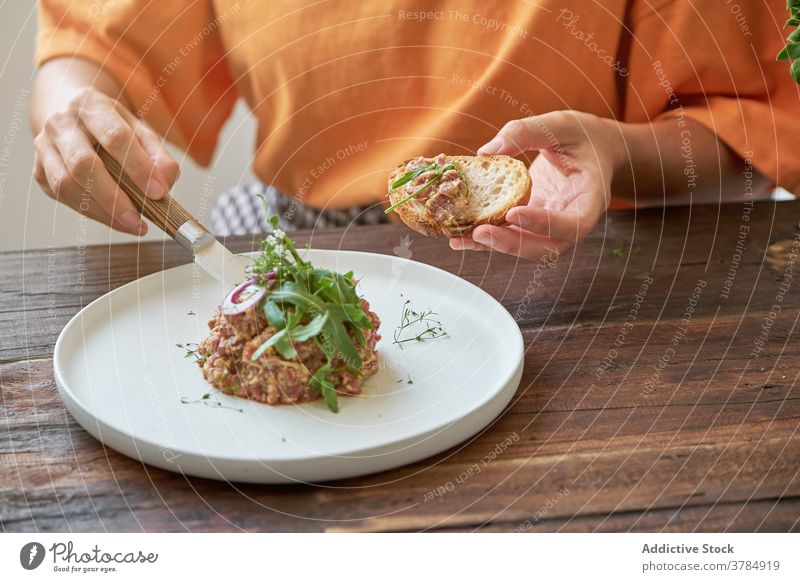 Nachdenkliche Frau mit leckerem Mittagessen zu Hause Steak Tartar anonym heimwärts genießen Speise Freude Sitzen Teller Tisch Glück Feinschmecker Gesundheit