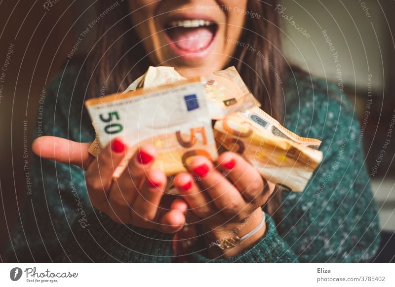 Eine Frau hält viel Geld in der Hand und freut sich sichtlich darüber. Reichtum, Erfolg, Gewinn. Geldscheine viele Freude Bargeld Euro Kapitalwirtschaft