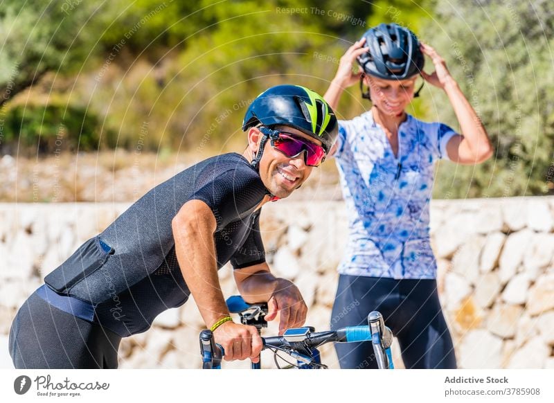 Fröhliches Radfahrerpaar Schutzhelm aktiv Glück Frau vorbereiten Paar sportlich behüten heiter Mitfahrgelegenheit jung Lachen Sicherheit Lifestyle Sport Lächeln