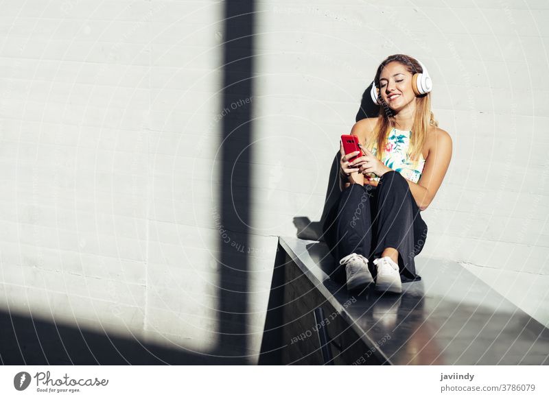 Mädchen mit einem Smartphone in Freizeitkleidung Frau Kopfhörer klug Telefon Teenager Generation Kaukasier gen z jung Person Lifestyle Mobile Funktelefon