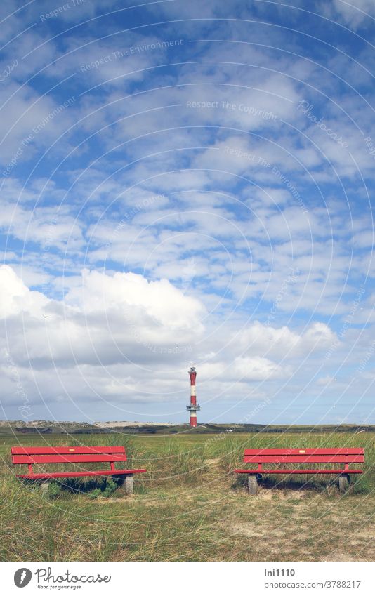 zwei rote Bänke im Hintergrund blauer Wolkenhimmel mit neuem Leuchtturm von Wangerooge Nordsee Insel Marschland schönes Wetter Dünen Weite einladend