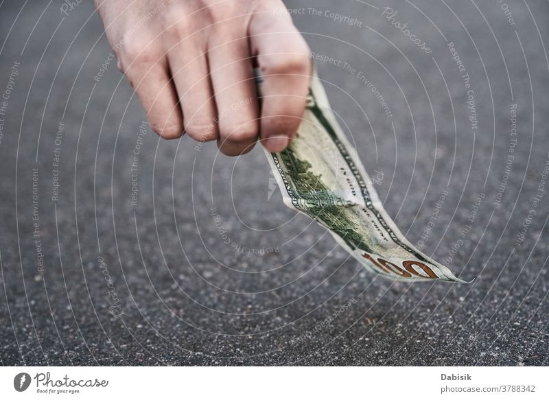 Heben Sie eine Hundert-Dollar-Banknote vom Boden auf. Konzept des gefundenen Geldes verirrt finden Straße im Freien Bürgersteig Person Tropfen Bargeld Rechnung