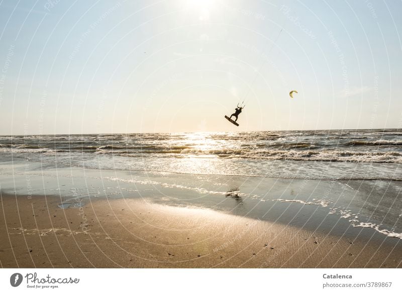 Kiter am Strand erhebt sich aus dem Wasser in die Luft Blau Sand Sandstrand Kitesurfen Urlaub Sport Meer Horizont Himmel Nordsee Wellen Brandung Küste Sonne