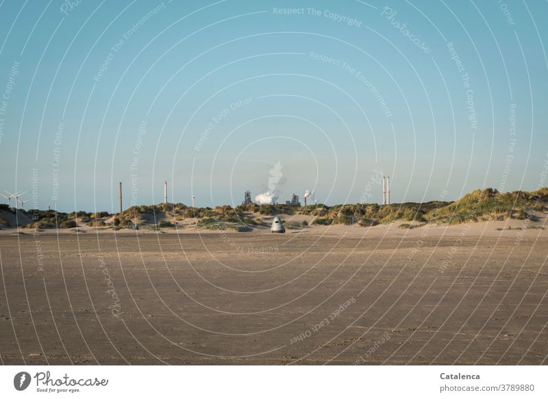 Ein kleines Ufo vor den Dünen am Strand, dahinter ein rauchendes Stahlwerk Sand Strandlandschaft Natur Küste Nordsee Ferien & Urlaub & Reisen Himmel