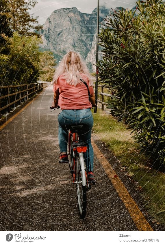 Junge Frau fährt Fahrrad am Gardasee gardasee norditalien torbole fahrrad radweg Berge u. Gebirge urlaub reisen bewegung jeans freizeit sommer sonne