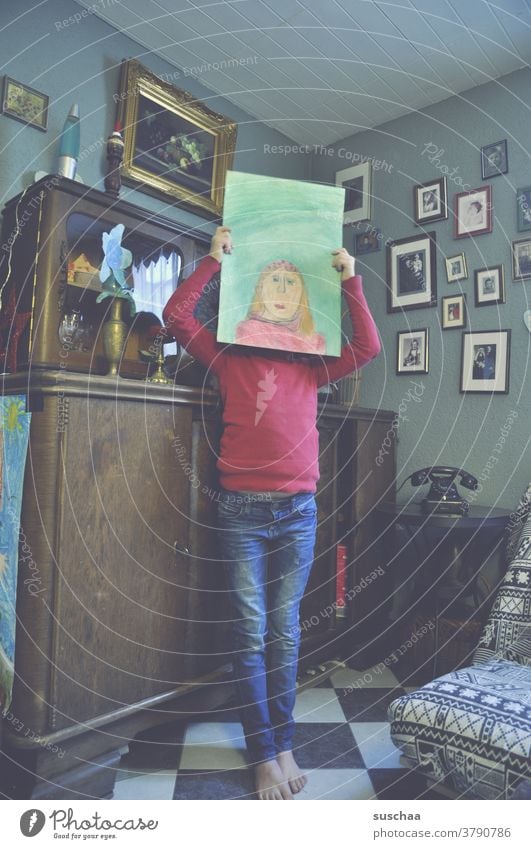 kind mit gemaltem selbstportrait vor dem kopf Kind Mädchen Selbstportrait Künstlerin Zeichnung Kopf Gesicht Papier Kunstwerk Wohnung wohnen altmodisch Bilder