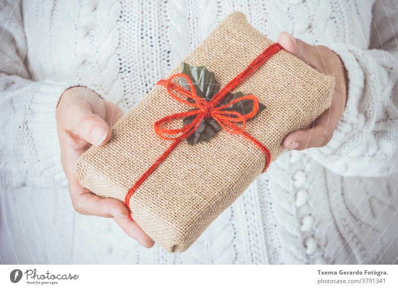 Frauenhände halten ein Weihnachtsgeschenk, das in einem rustikalen Kasten Weihnachten handgefertigt Hände Hipster weiß Hintergrund Postkarte Feiertag Dezember