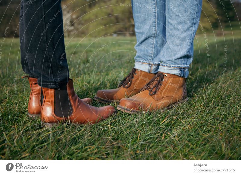 Stiefel von Mann und Frau Gras außerhalb Liebe Paar Nahaufnahme Sportrasen Jeanshose Erwachsene Zusammensein 2 Farbfoto Partner 18-30 Jahre