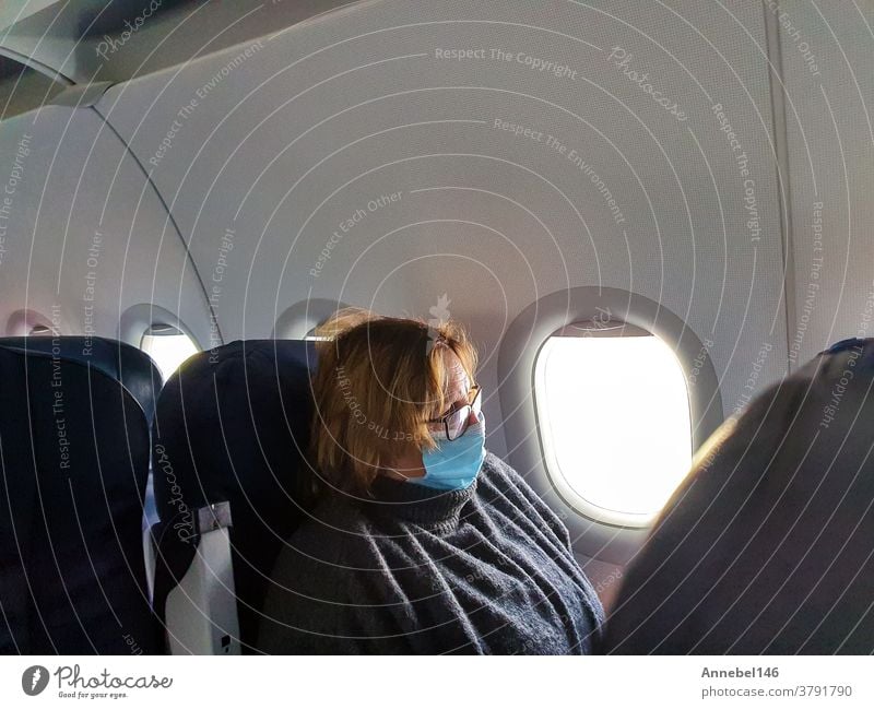 Alte ältere Frau reist mit medizinischer Schutzmaske für Covid-19, Reisen und Coronavirus-Konzept reisen Flug Mundschutz Flugzeug Tourist Virus Ausflug