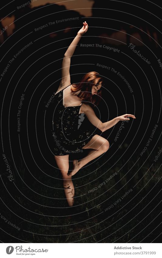 Anmutige Frau tanzt im dunklen Park Balletttänzer Ballerina Tänzer dunkel Wiese Choreographie beweglich Talent Island Kleid Natur elegant Gleichgewicht Künstler