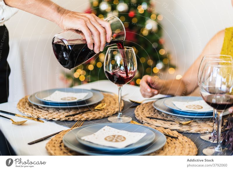 Mann serviert Wein an Heiligabend Weihnachten jubelt Servieren Weinglas Zuprosten gesichtslos feiern sich[Akk] sammeln Beschnittansicht Freund heiter festlich