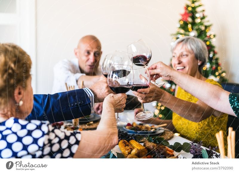 Fröhliche Freunde mit Rotwein bei der Weihnachtsfeier zu Hause jubelt Glas feiern Glück Weihnachten Lebensmittel festlich Abendessen sich[Akk] sammeln Tisch