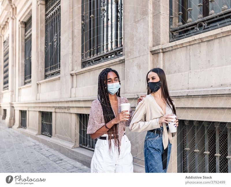 Diverse Frauen mit Kaffee zum Mitnehmen auf der Straße beglückt Imbissbude Spaziergang Coronavirus Bund 19 Wochenende Großstadt multiethnisch rassenübergreifend