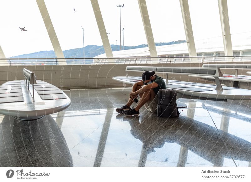 Reisender Mann sitzt im Flughafen Abheben räkeln Mundschutz Bund 19 Projekt geschlagen männlich niedergeschlagen Tourist reisen Ausflug Gerät Smartphone Mobile