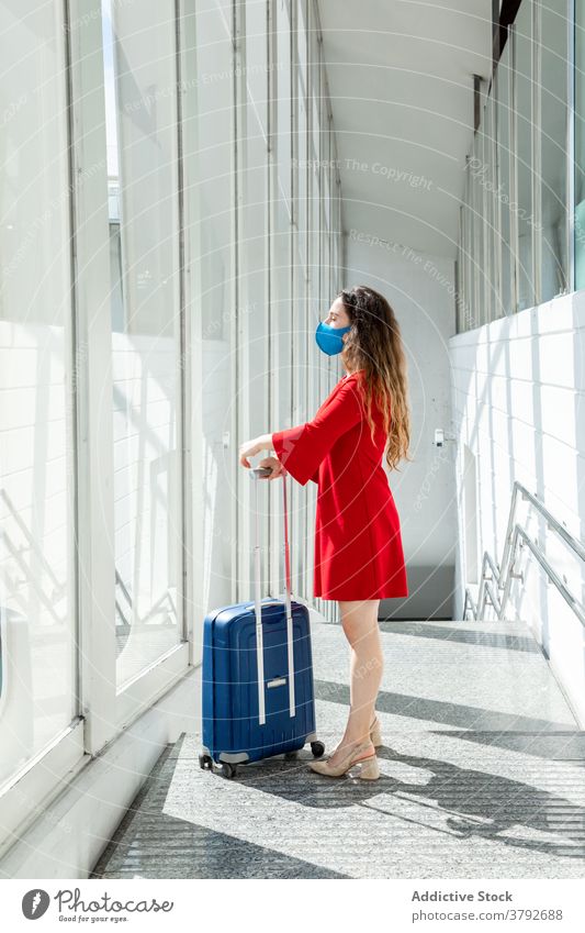 Reisende Frau mit Gepäck im Flughafen reisen warten Abheben Koffer Mundschutz Coronavirus Tourist Passagier Urlaub Feiertag Fenster Ausflug Reisender modern