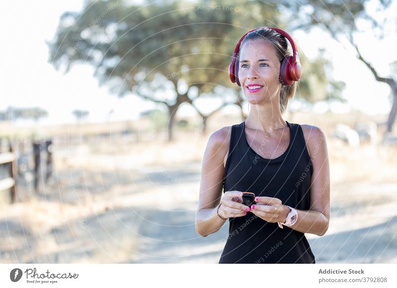 Frau benutzt MP3-Player und Kopfhörer im Park Apparatur zuhören mp3 Spieler benutzend Klang Melodie Audio Podcast Musik unterhalten Gesang jung Konzentration