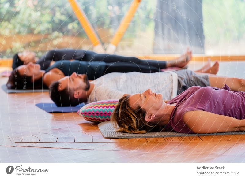 Menschen in Shavasana-Pose auf Yogamatten shavasana sich[Akk] entspannen Augen geschlossen meditieren Zen friedlich Harmonie Klasse Lügen Stock reflektierend