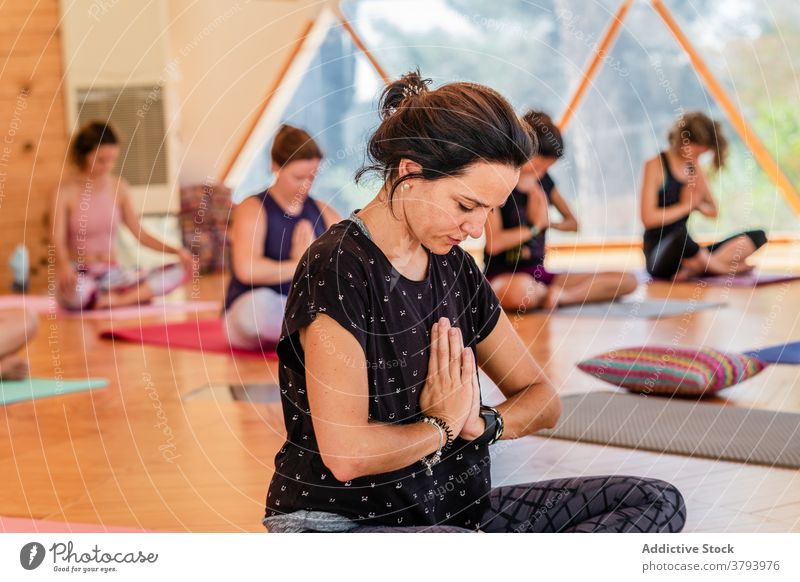 Frauen mit Gebet Hände üben Yoga im Unterricht Namaste Beine gekreuzt Sprit Augen geschlossen Stressabbau Lektion eingedenk Hand padmasana meditieren