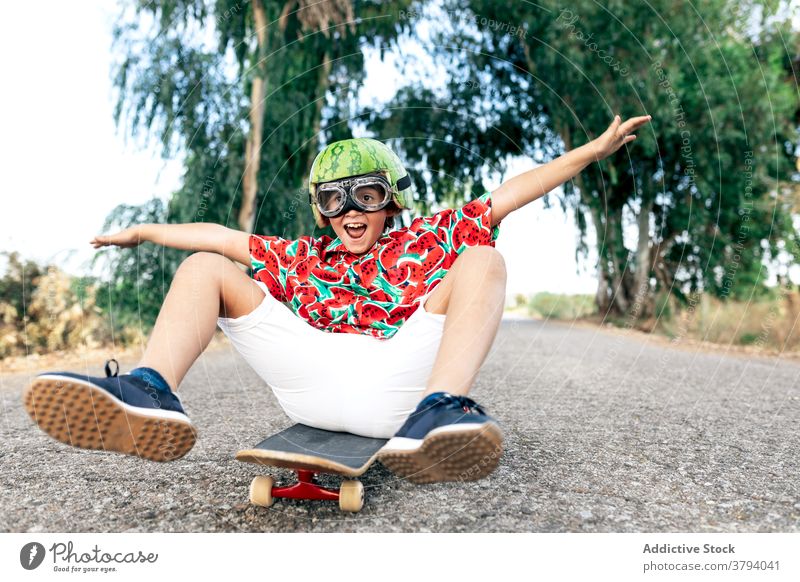 Glücklicher Junge auf Skateboard in Schutzbrille Schutzhelm Spaß haben sorgenfrei Kindheit aufgeregt Inhalt Straße stylisch Bekleidung Brille dekorativ Sommer