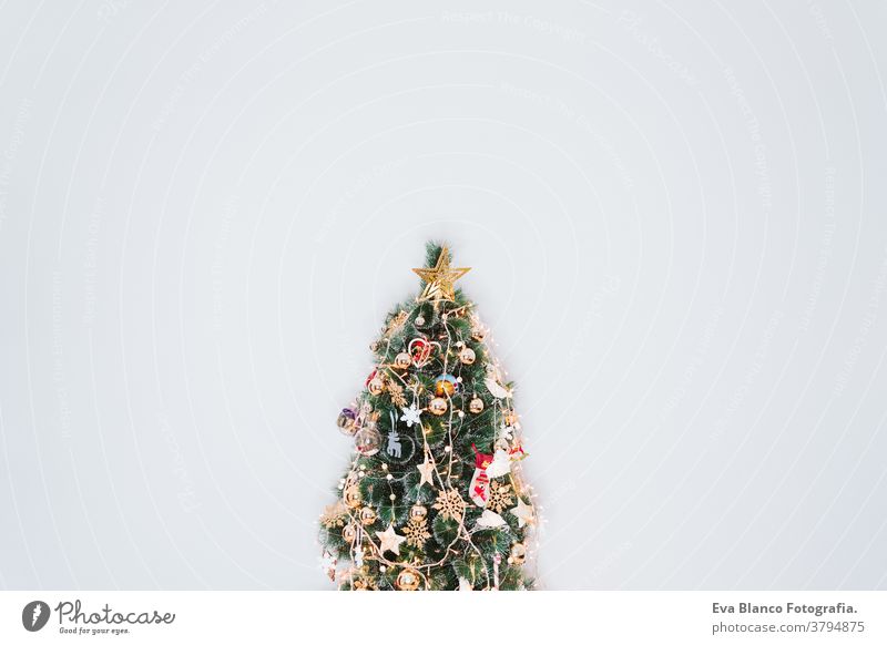 Zu Hause mit Lichter geschmückter Weihnachtsbaum über weißer Wand. Weihnachtskonzept drinnen Baum heimwärts Urlaub Weihnachtsmann im Innenbereich niemand Nacht