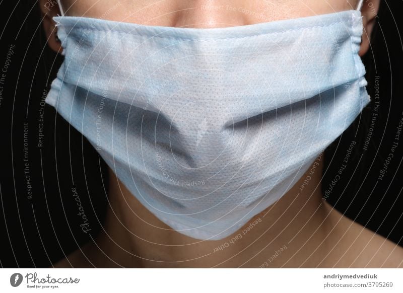 Junge Frau, die eine medizinische Gesichtsmaske trägt, um Infektionen, Krankheiten oder Grippe und 2019-nCoV vorzubeugen. Schwarzer Hintergrund. Schutz vor Krankheit, Coronavirus.