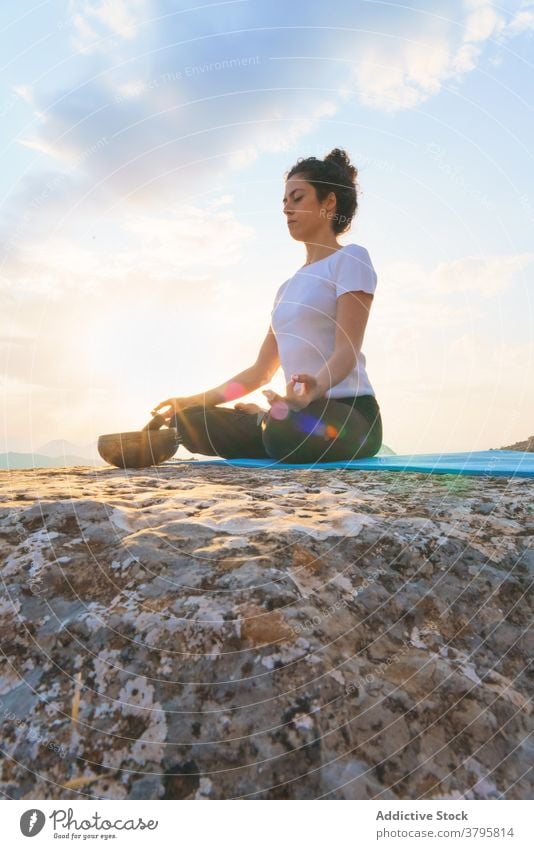 Entspannte Frau meditiert auf einem Berggipfel Yoga meditieren Lotus-Pose Gleichgewicht Zen Gelassenheit friedlich Natur Berge u. Gebirge sitzen Asana padmasana