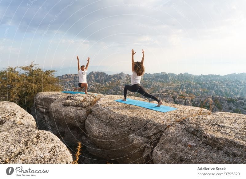 Paar stehend in Yoga Asana auf Felsen halbmondförmiger Ausfallschritt Berge u. Gebirge Natur üben Zusammensein Pose Akro-Yoga positionieren Wellness Lifestyle