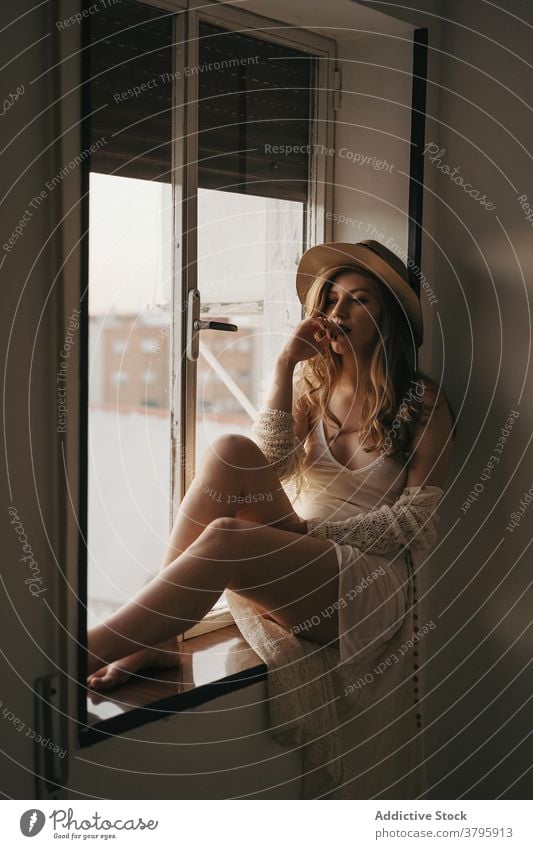 Sinnlich nachdenkliche Frau in stilvoller Kleidung auf der Fensterbank sinnlich stylisch Bekleidung nachdenken feminin sensibel Melancholie Fenstersims