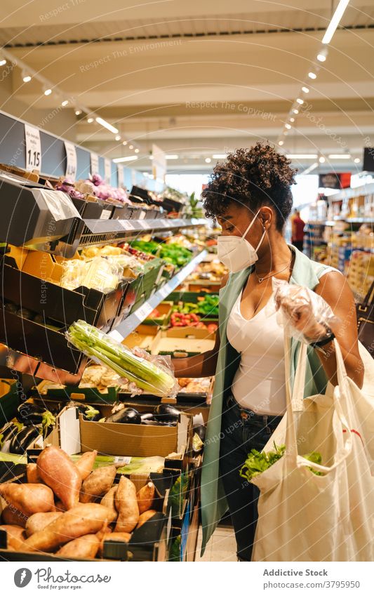 Schwarze Frau kauft Früchte im Lebensmittelladen Frucht wählen kaufen Coronavirus Mundschutz COVID Lebensmittelgeschäft Werkstatt Supermarkt Gesunder Lebensstil