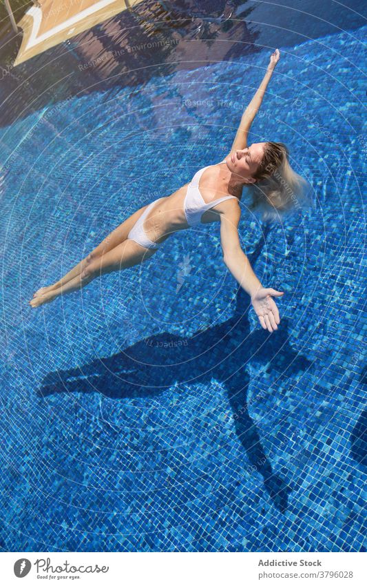 Entspannte junge Dame genießt Sommertag beim Sonnenbaden Pool Frau Kälte Reisender räkeln Augen geschlossen Glück sich[Akk] entspannen Urlaub Resort Feiertag