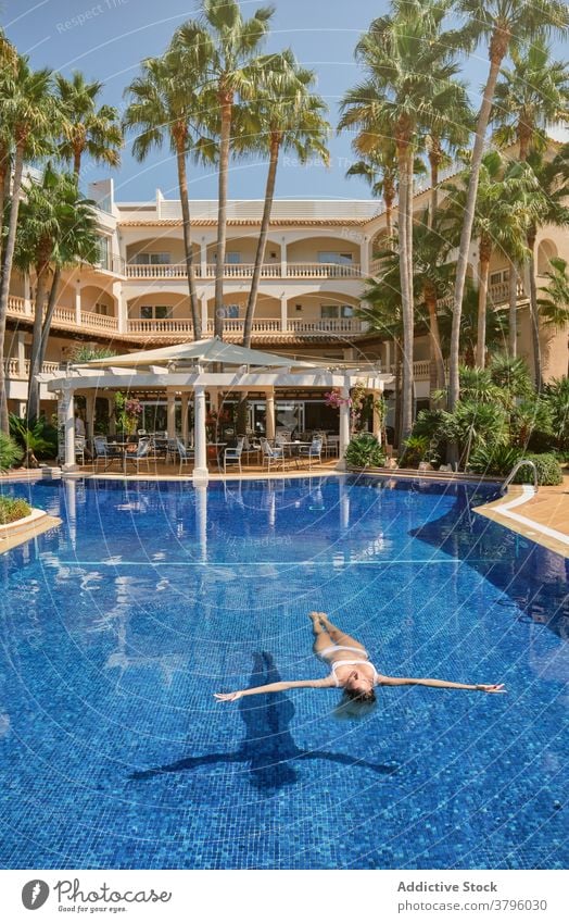 Entspannte junge Dame genießt Sommertag beim Sonnenbaden Pool Frau Kälte Reisender räkeln Augen geschlossen Glück sich[Akk] entspannen Urlaub Resort Feiertag