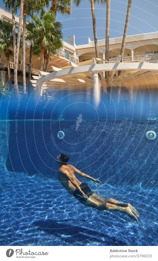 Unerkennbare Person, die in ein Schwimmbecken taucht Pool Sinkflug schwimmen unter Wasser Sommer Resort Feiertag Erfrischung tropisch Aktivität platschen