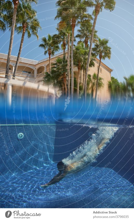 Unerkennbare Person, die in ein Schwimmbecken taucht Pool Sinkflug schwimmen unter Wasser Sommer Resort Feiertag Erfrischung tropisch Aktivität platschen