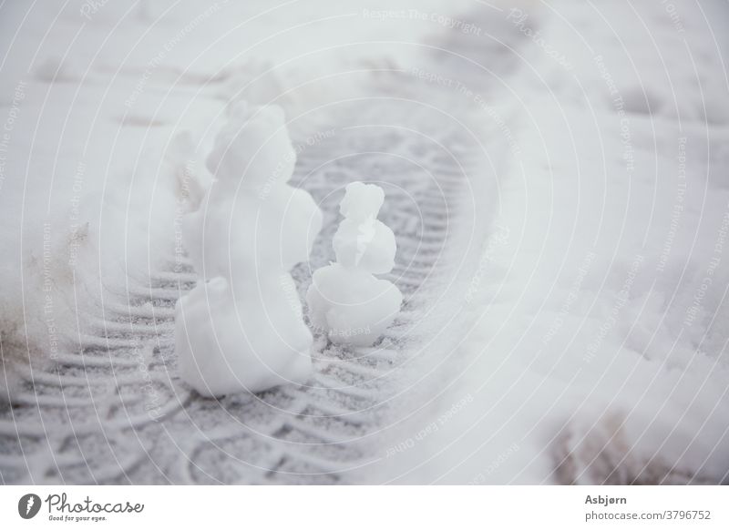 Zwei Schneemänner im Miniaturformat Winter Wetter PKW Reifen Wagenräder Paar Farbfoto Außenaufnahme Reifenprofil Straße Reifenspuren kalt Strukturen & Formen