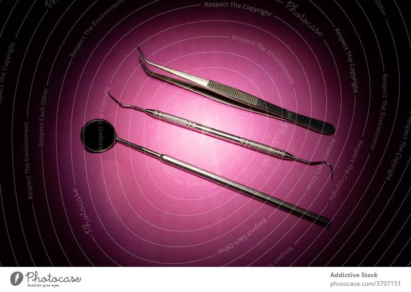 Zahnärztliche Werkzeuge auf rosa Hintergrund dental Klinik Instrument Metall verschiedene Spiegel Entdecker Baumwolle forcep Reihe Gerät Medizin Kulisse