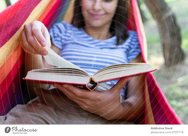 Entspannte Frau liest Buch in Hängematte lesen Etage genießen Sommer Lügen Park Literatur interessant friedlich Roman ruhig lässig Hobby Natur Erholung