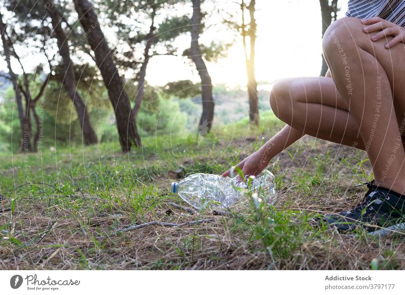 Crop Frau Kommissionierung Müll im Wald Kunststoff verschmutzen pflücken Abfall Ökologie Problematik natürlich Freiwilliger Flasche Wälder Umwelt Natur Pflege