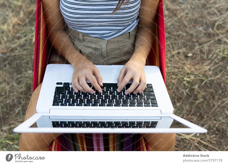 Frau in Hängematte mit Laptop freiberuflich Projekt benutzend Tippen Inbetriebnahme unabhängig jung Internet Apparatur Gerät Netbook Browsen Lügen Arbeit