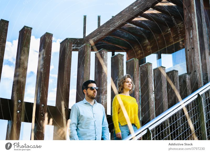 Seriöses Paar auf Brücke stehend Stil trendy emotionslos Grunge Bekleidung Outfit Sommer Konstruktion Treppe Treppenhaus Schritt jung Zusammensein Partnerschaft