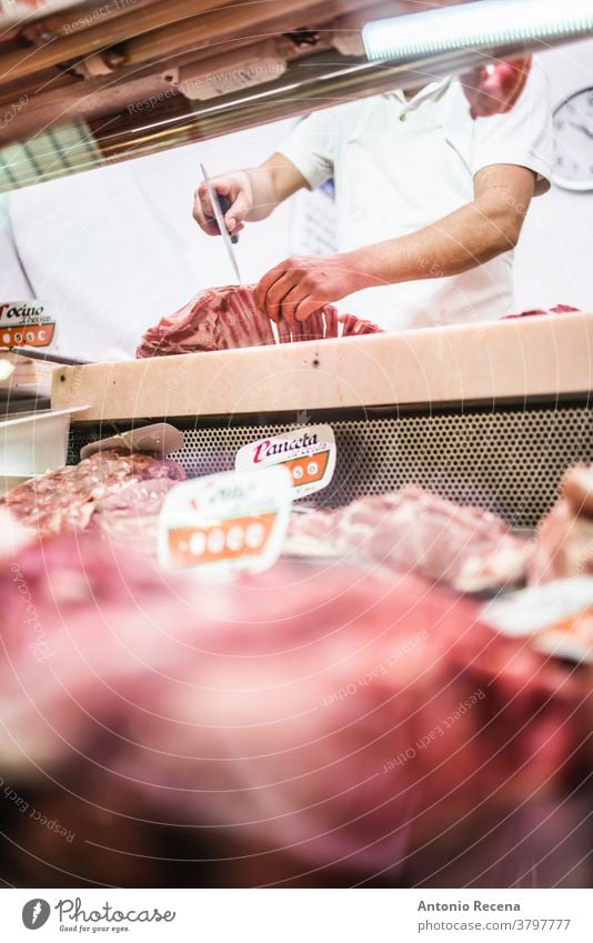Metzger zerlegt Fleisch und bereitet es für den Verzehr auf einem Markt vor Waffen anonym Produkt Lebensmittel realistisch reales Leben Mann Arbeit